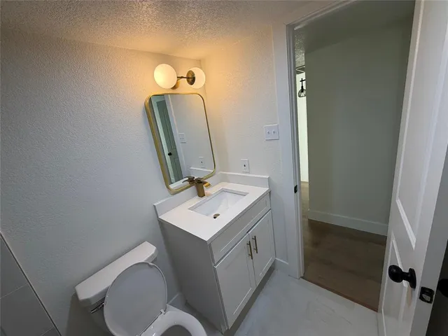 a bathroom with a toilet a sink and mirror