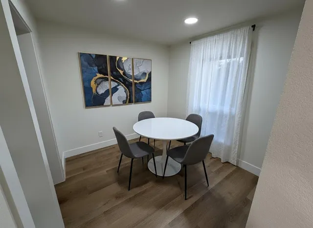 a view of a dining room with furniture and wooden floor