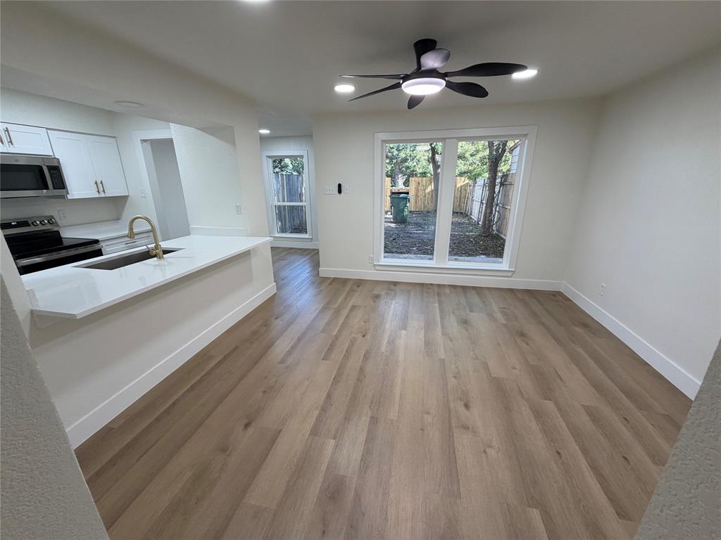 424 Valley Park Drive Garland, TX 75043 - Photo 6 of 18 a large kitchen with a large window a sink and stainless steel appliances
