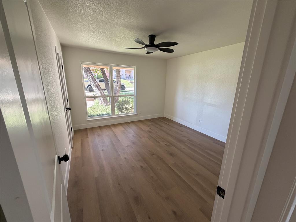 424 Valley Park Drive Garland, TX 75043 - Photo 8 of 18 a view of an empty room with wooden floor and a window