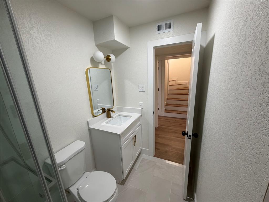 424 Valley Park Drive Garland, TX 75043 - Photo 10 of 18 a bathroom with a toilet sink and mirror