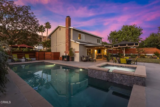 a view of a house with pool and sitting area