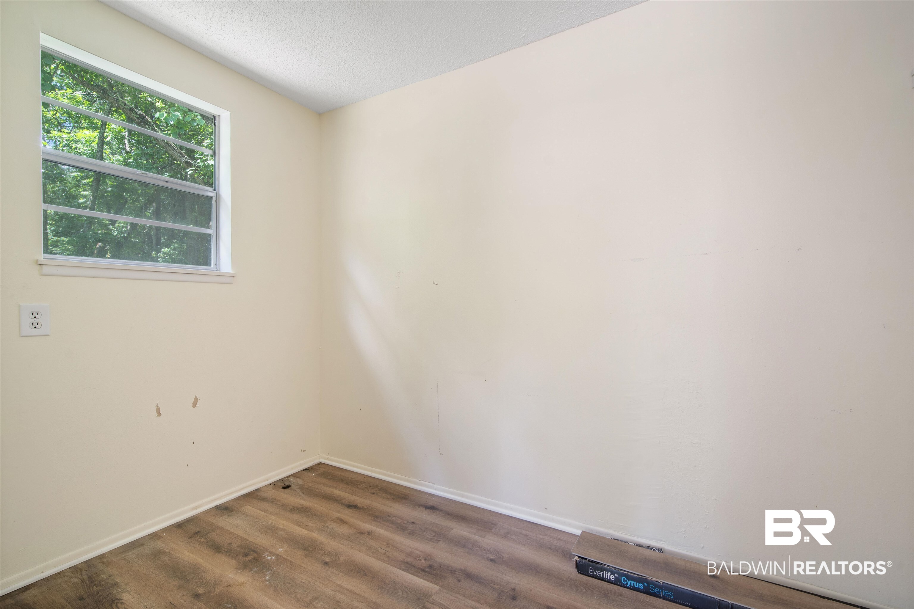 1325 Pawnee Circle Saraland, AL 36571 - Photo 21 of 26 Spare room with wood finished floors and a textured ceiling