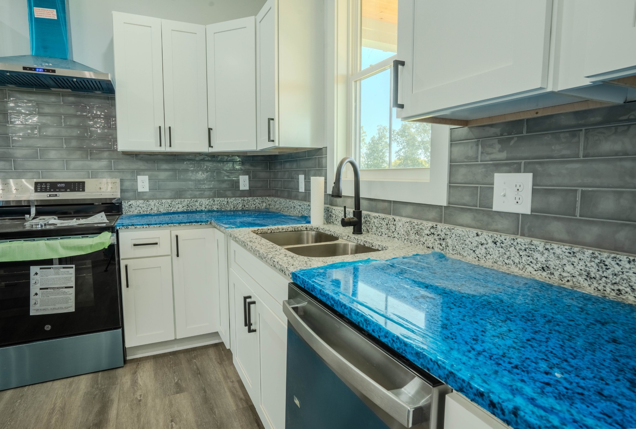176 Beartown Road Loretto, TN 38469 - Photo 14 of 46 a kitchen with granite countertop a sink a stove and cabinets
