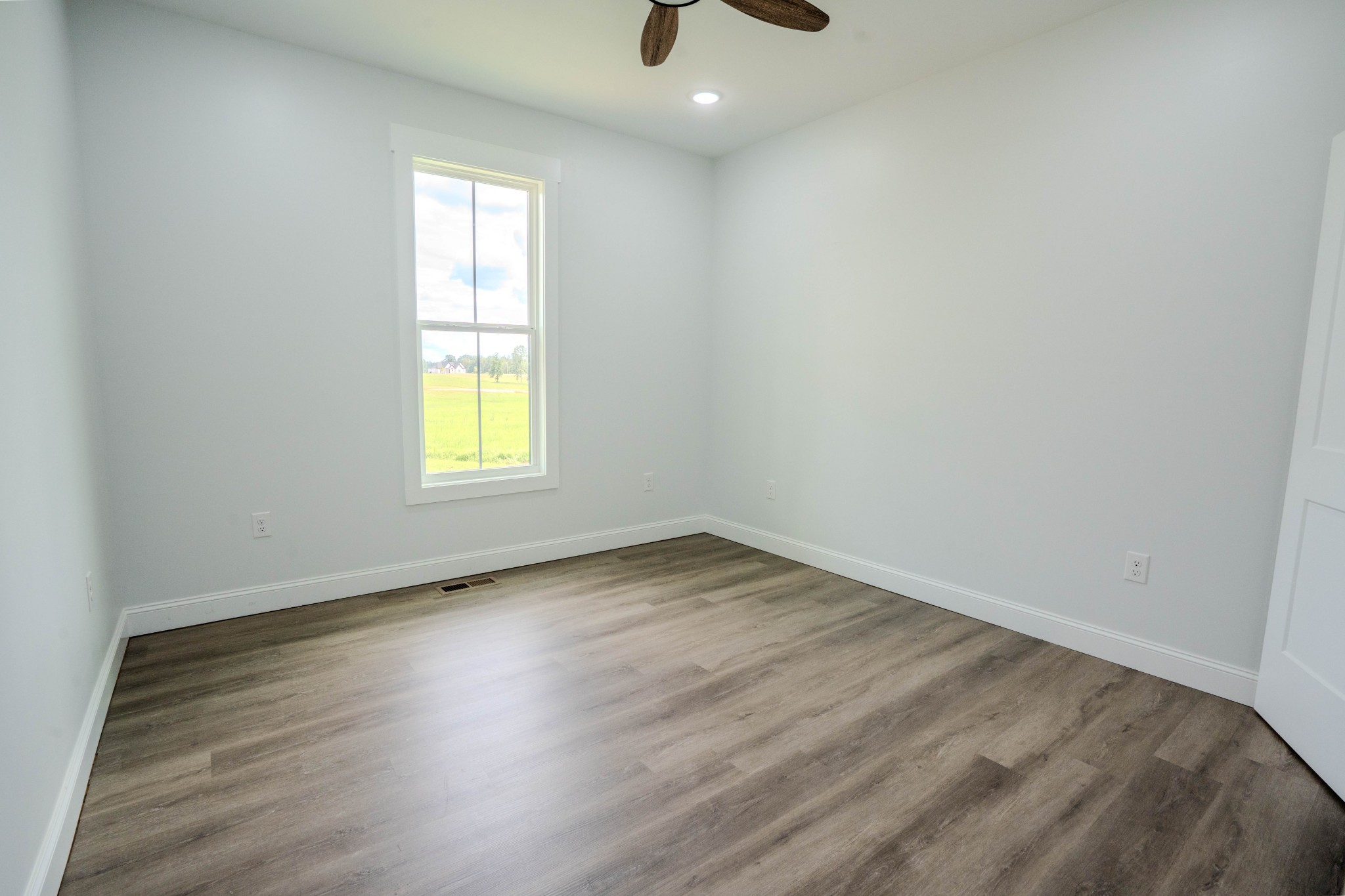 176 Beartown Road Loretto, TN 38469 - Photo 19 of 46 an empty room with wooden floor and windows