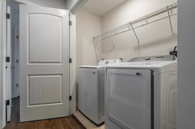a utility room with cabinets and wooden floor