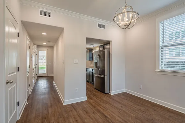 a view of hallway with wooden floor and chandelier