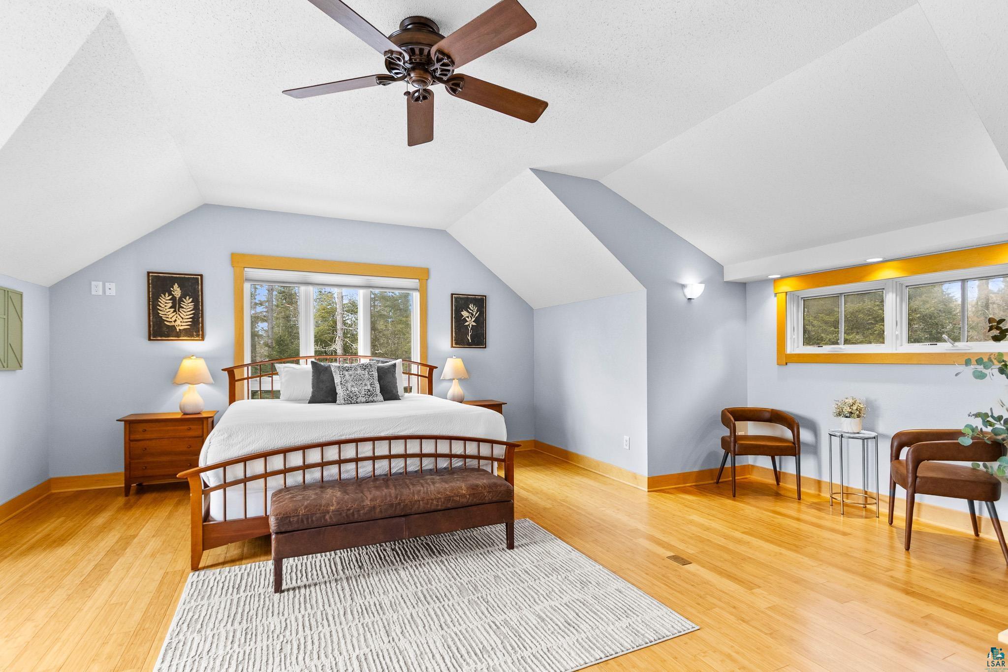 5163 Greenwood Road Duluth, MN 55804 - Photo 16 of 47 Vaulted ceiling with a ceiling fan, light wood-finish flooring, and multiple windows with wood trim