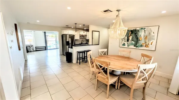 a dining room with stainless steel appliances furniture a window and kitchen view