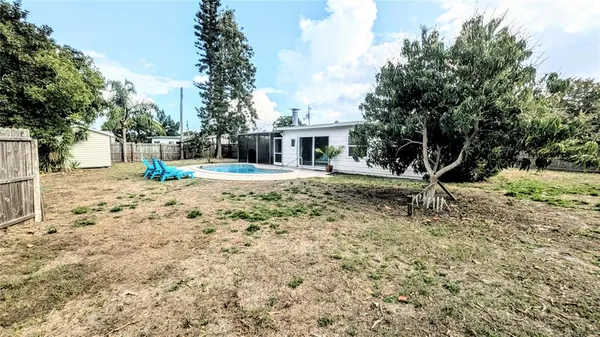 a view of a backyard with wooden fence and large trees