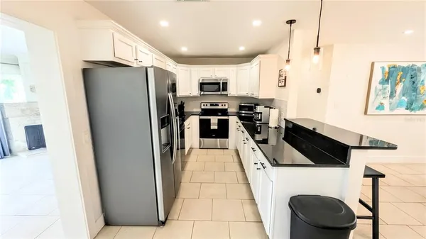 a kitchen with stainless steel appliances granite countertop a refrigerator a stove and a sink