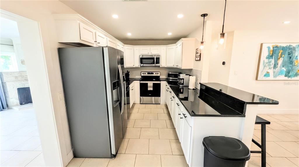 4515 Spahn Street Sarasota, FL 34232 - Photo 6 of 37 a kitchen with stainless steel appliances granite countertop a refrigerator a stove and a sink