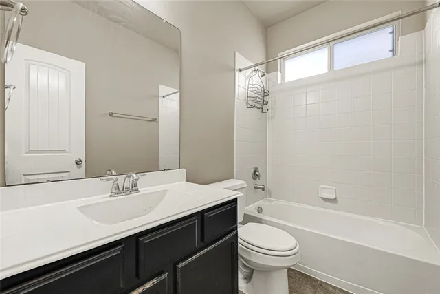 a bathroom with a sink a toilet a mirror and shower