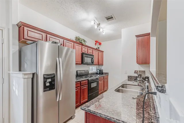 a kitchen with stainless steel appliances granite countertop a sink stove and microwave