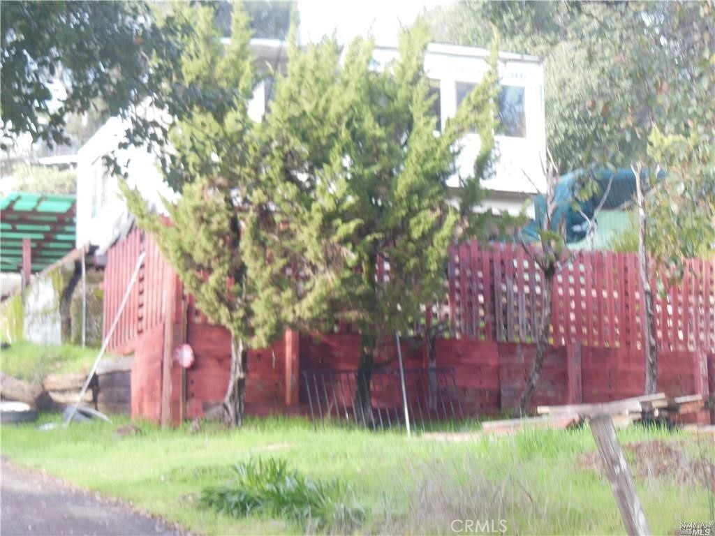 a front view of a house with a yard and tree