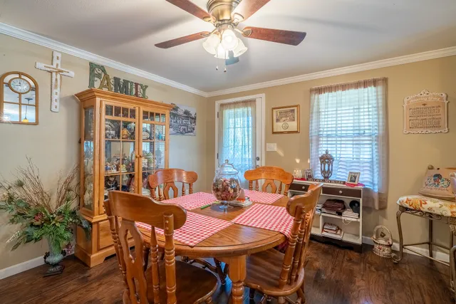 a living room with furniture a flat screen tv and a dining table