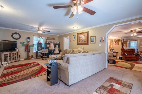 a living room with furniture a flat screen tv and a large window
