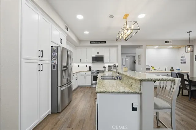 a kitchen with stainless steel appliances granite countertop a stove refrigerator and a wooden cabinets