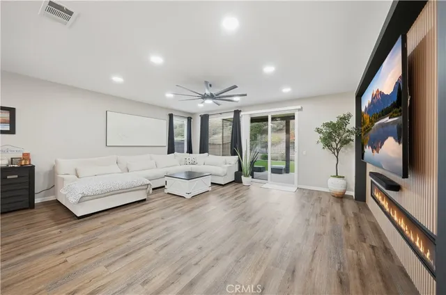 a living room with furniture flat screen tv and a large window