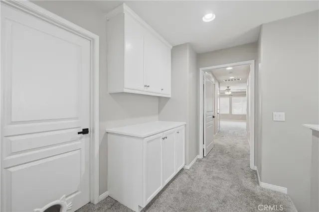 a view of a hallway to rooms and stairs