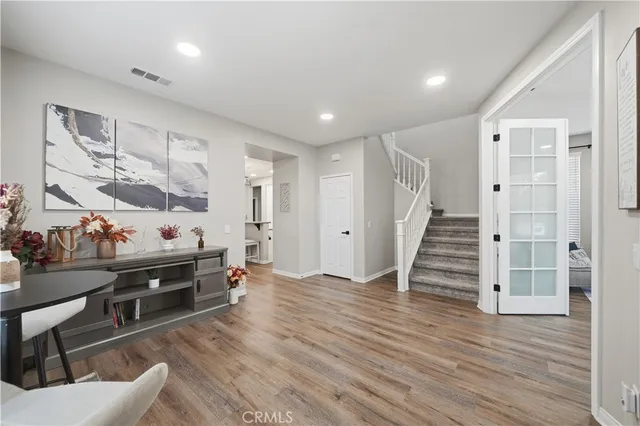 a view of a livingroom with wooden floor and white cabinet