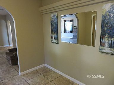 219 Larkspur Street Ridgecrest, CA 93555 - Photo 4 of 34 a view of a hallway with wooden floor and a living room