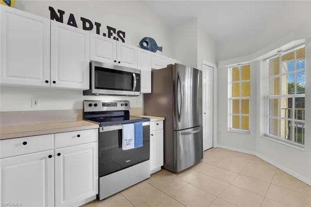a dining room with furniture a large window and chandelier