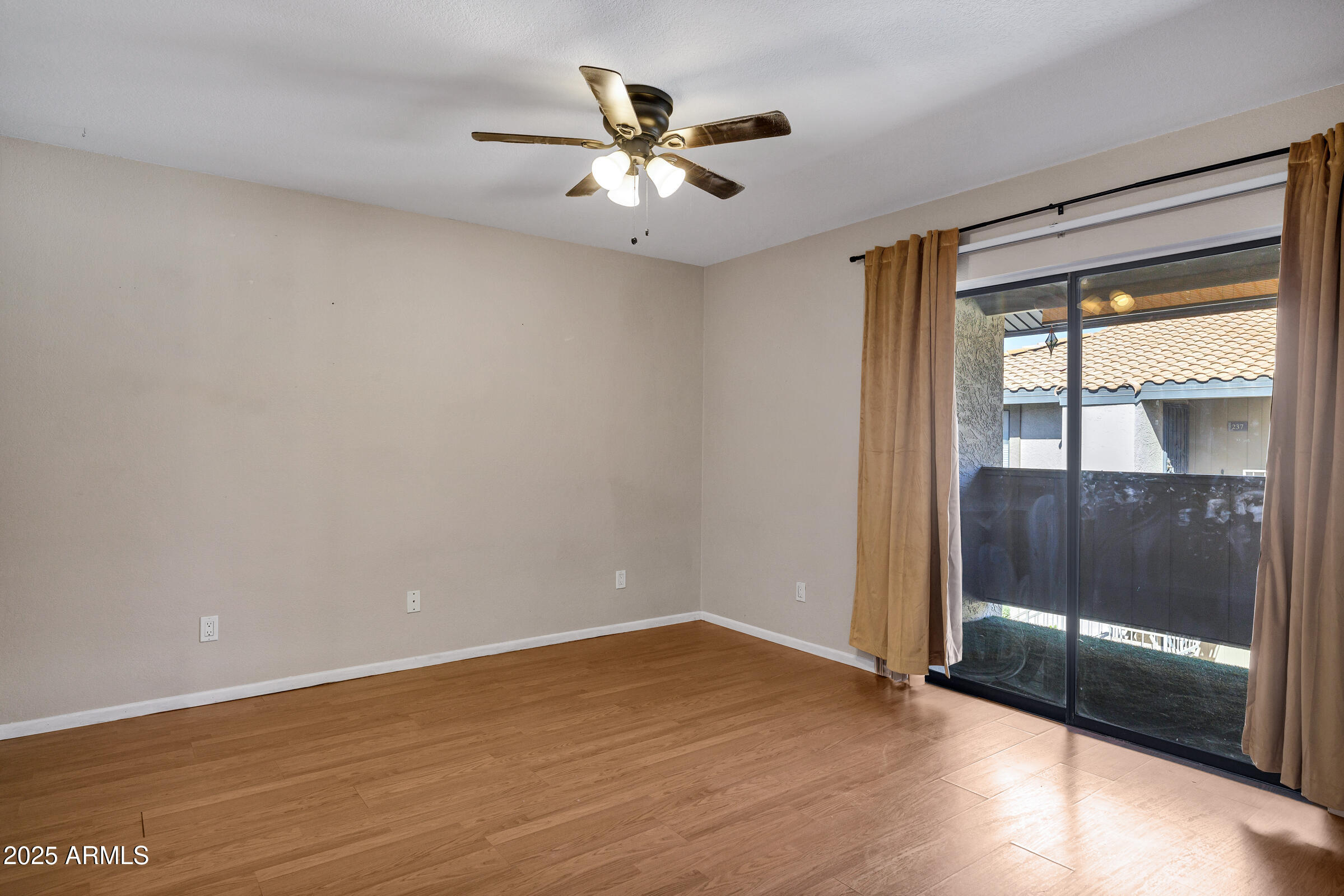 1402 East Guadalupe Road, Unit 248 Tempe, AZ 85283 - Photo 15 of 27 an empty room with wooden floor and fan