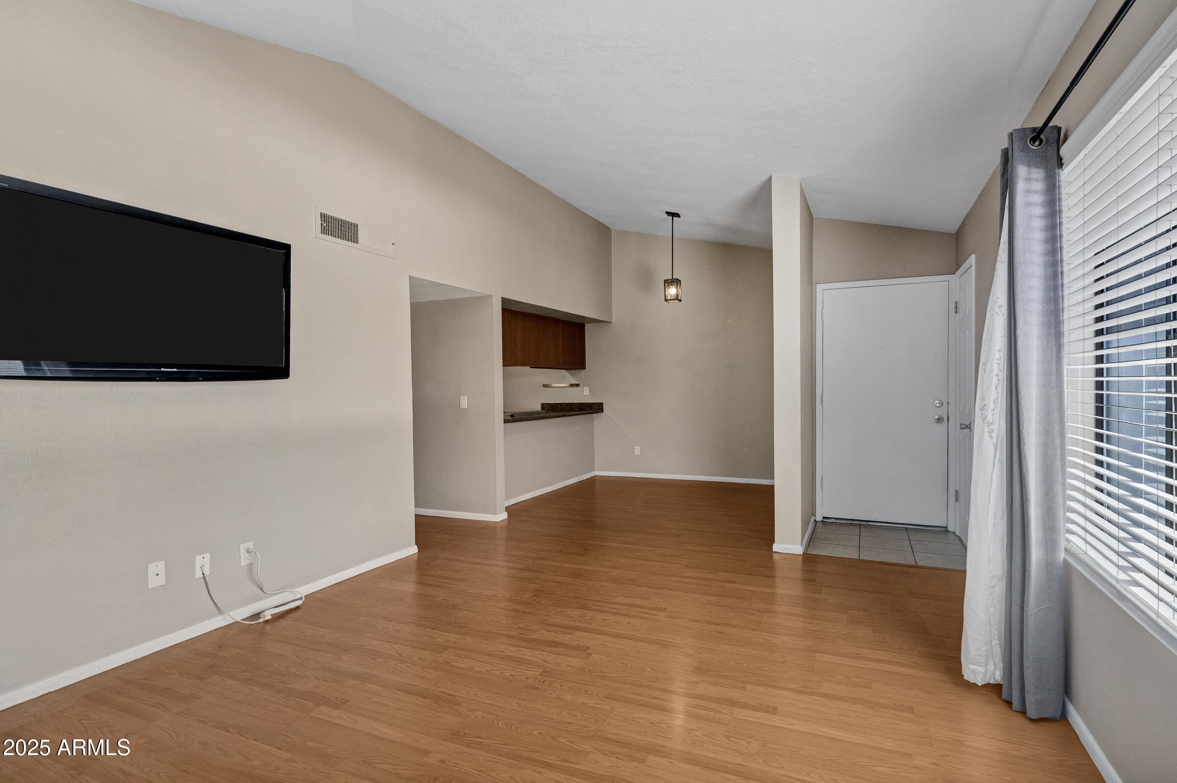 1402 East Guadalupe Road, Unit 248 Tempe, AZ 85283 - Photo 5 of 27 a view of an empty room with wooden floor and a window