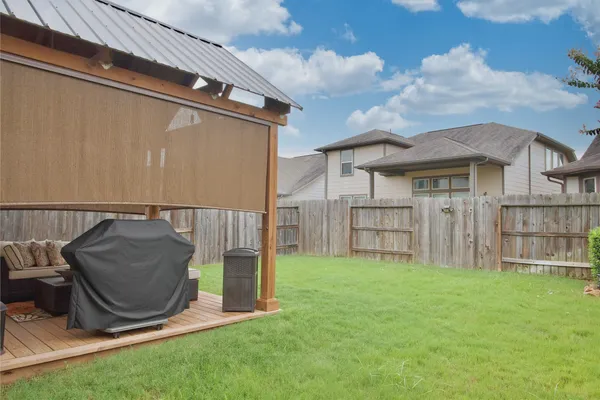 a view of backyard with cabin and wooden fence