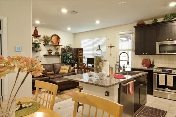 a kitchen with stainless steel appliances kitchen island granite countertop a sink and cabinets