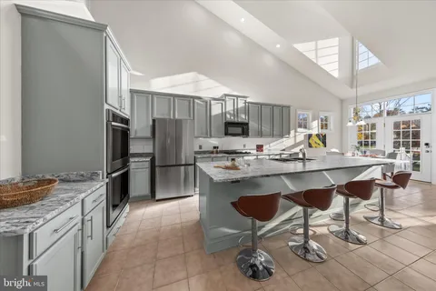 a dining room filled chandelier and kitchen view