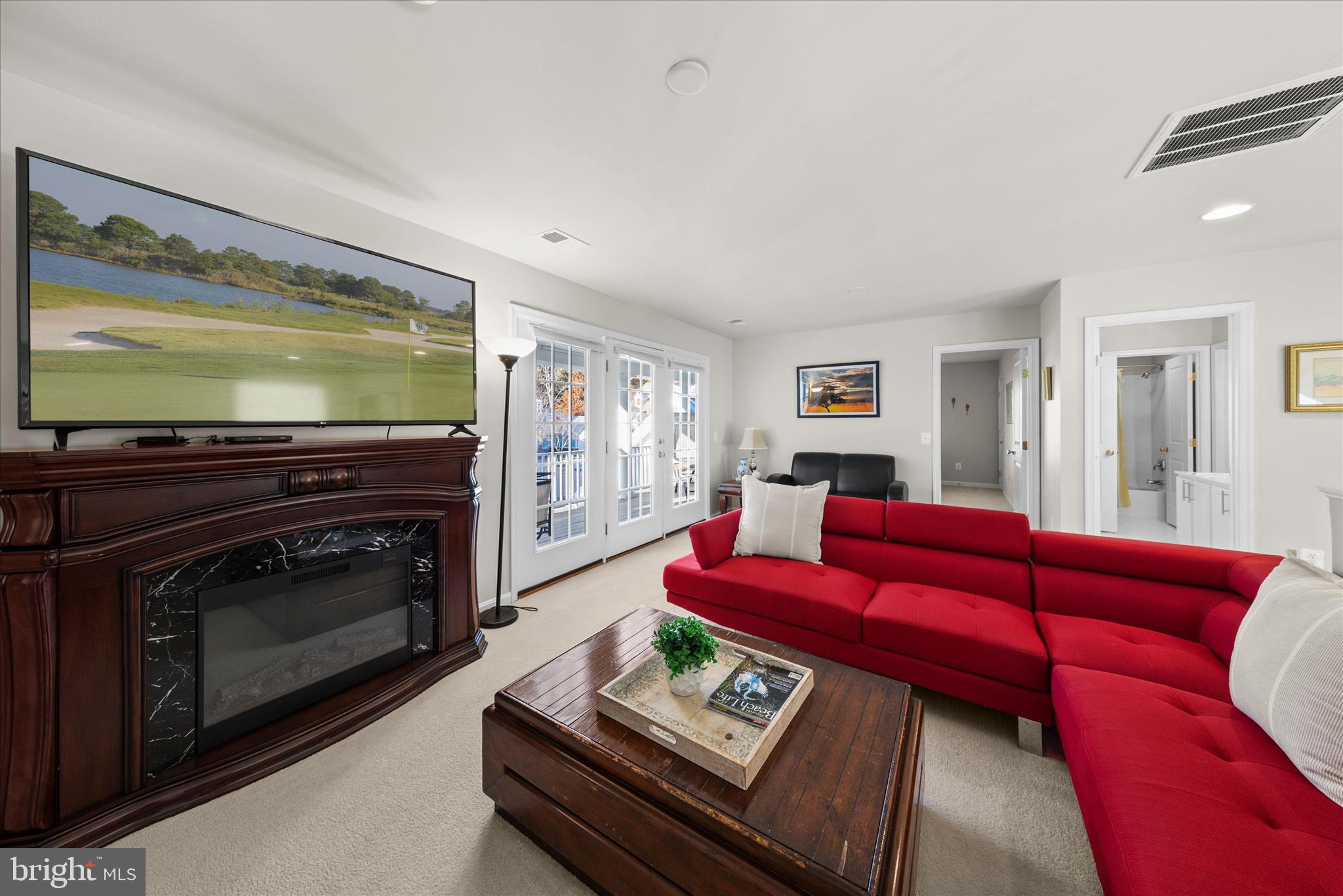 33067 Secluded Path, Unit 125 Millsboro, DE 19966 - Photo 41 of 64 a living room with furniture a flat screen tv and a fireplace