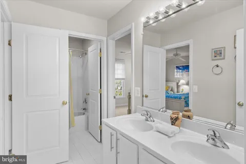 a bathroom with a bathtub a sink a mirror and a shower