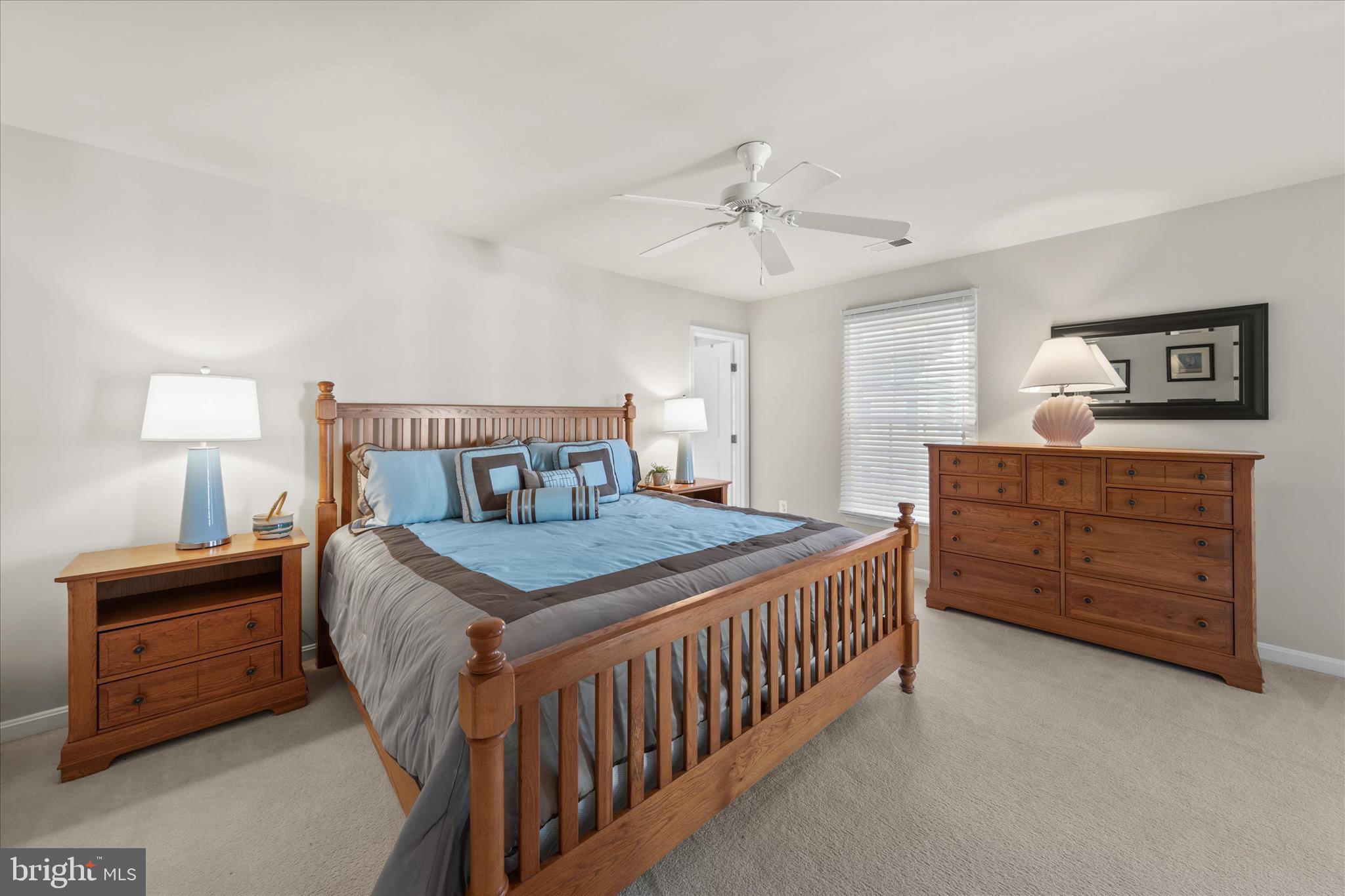 33067 Secluded Path, Unit 125 Millsboro, DE 19966 - Photo 52 of 64 a bedroom with a bed a dresser and a chandelier