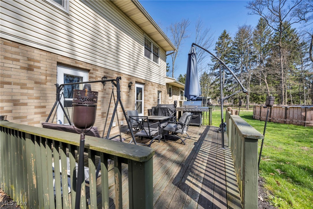 725 Neal Road, Unit 723 Akron, OH 44312 - Photo 35 of 47 Deck featuring grilling area, outdoor dining area, and a yard