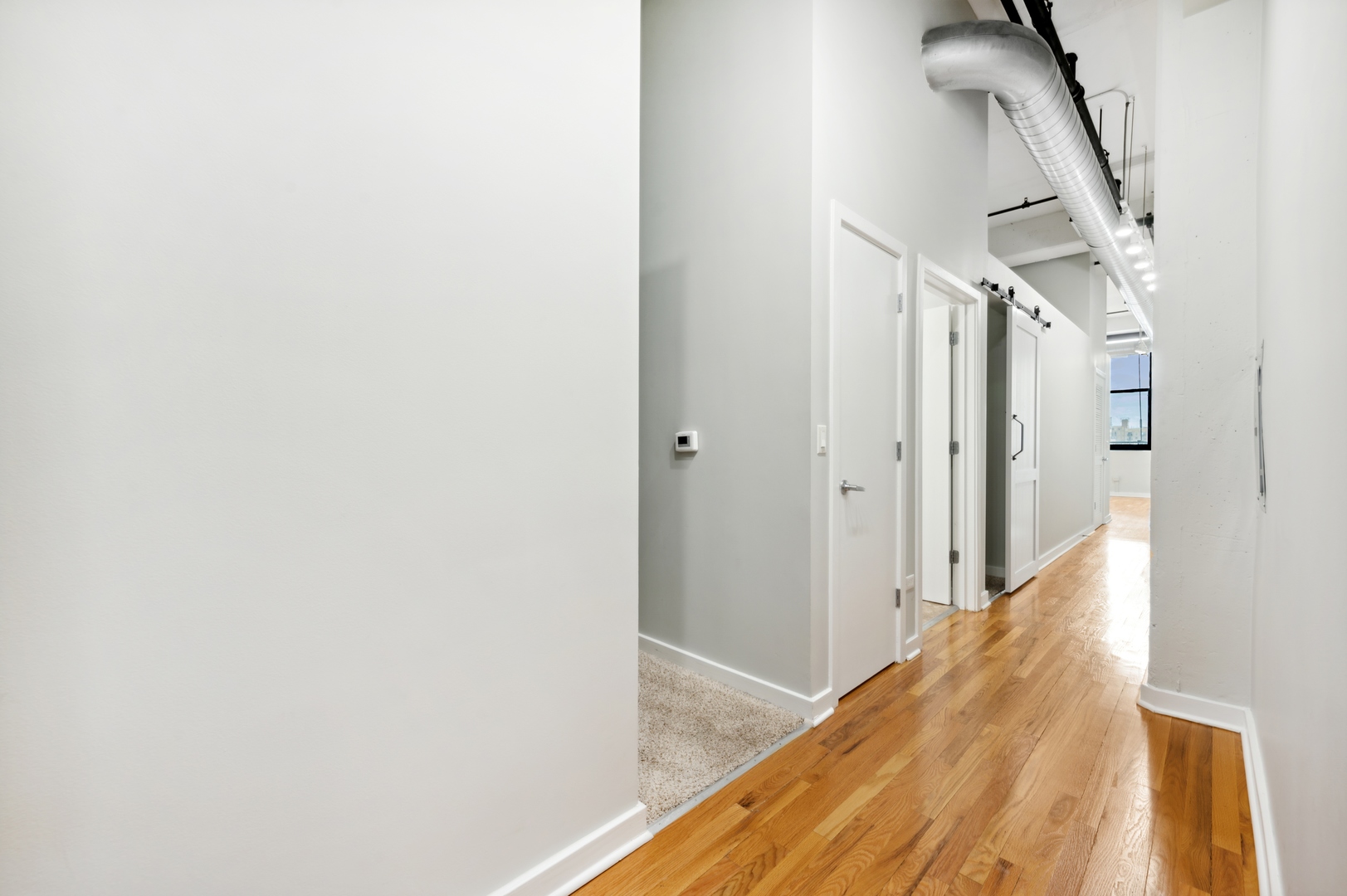 1224 West Van Buren Street, Unit 300 Chicago, IL 60607 - Photo 2 of 18 a view of a hallway with wooden floor and staircase