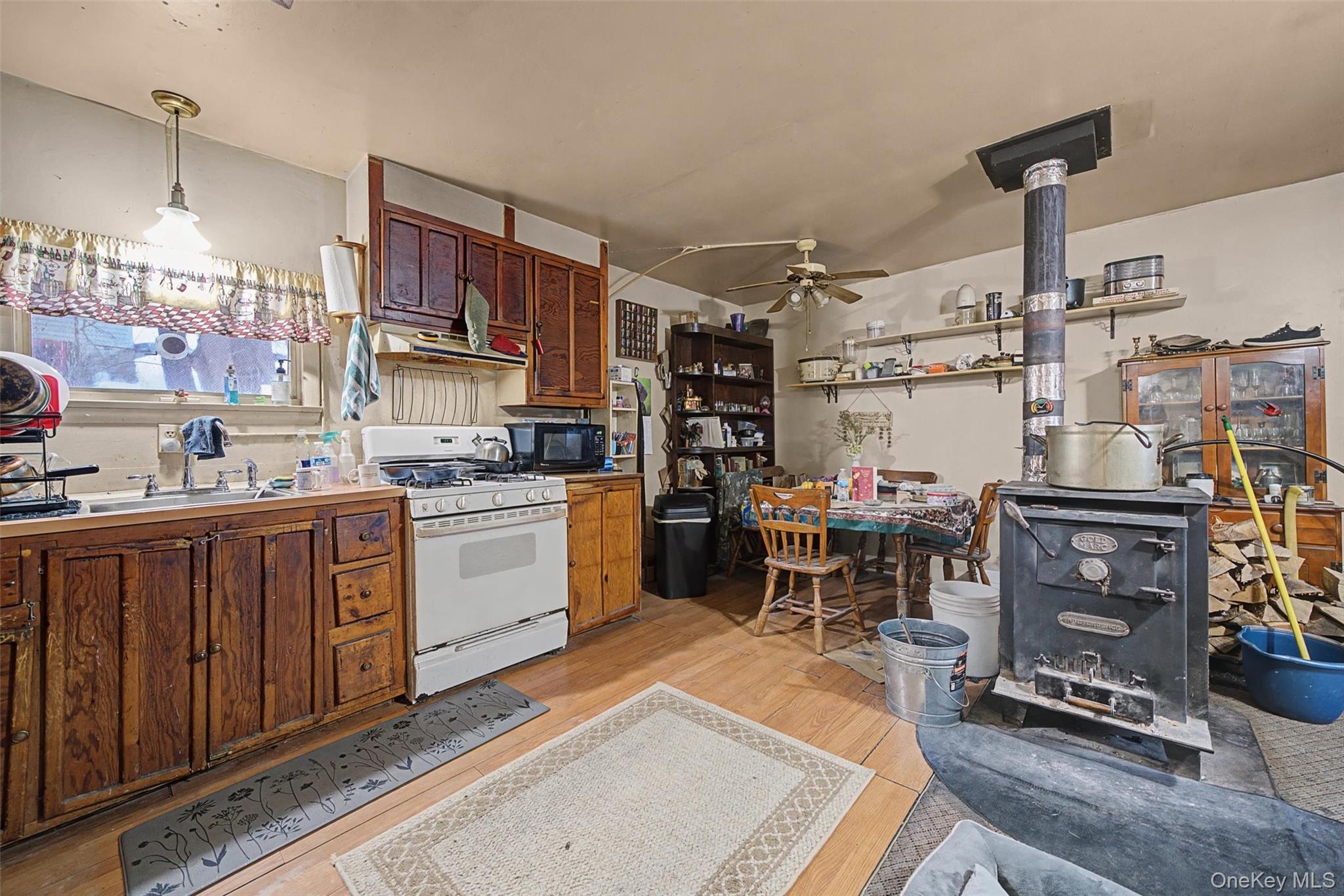 2 Station Hill Road, Unit 4 Ferndale, NY 12734 - Photo 14 of 25 Kitchen featuring a wood stove, white gas range, light wood-type flooring, wood finish cabinets, and ceiling fan