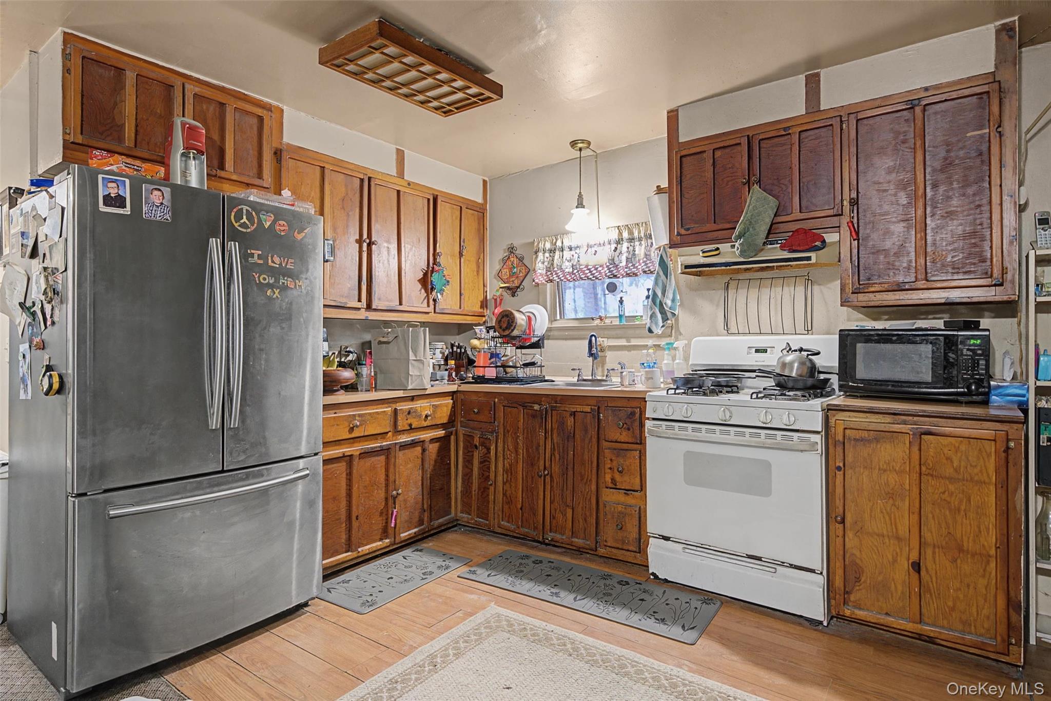 2 Station Hill Road, Unit 4 Ferndale, NY 12734 - Photo 15 of 25 Kitchen with freestanding refrigerator, white gas stove, decorative light fixtures, black microwave, and light countertops