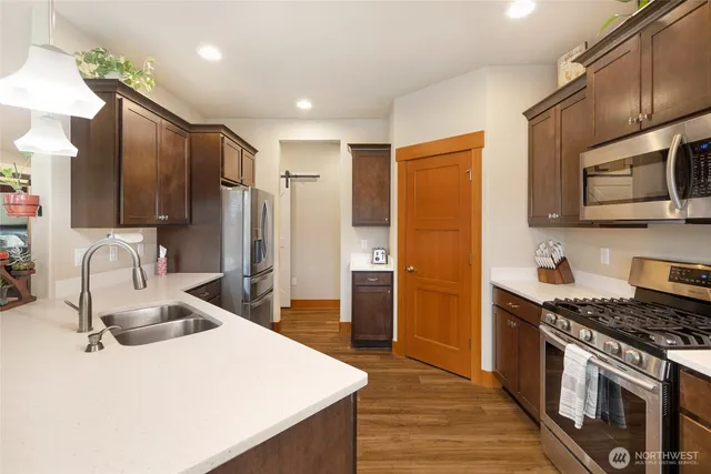 a kitchen with stainless steel appliances granite countertop a sink stove and refrigerator