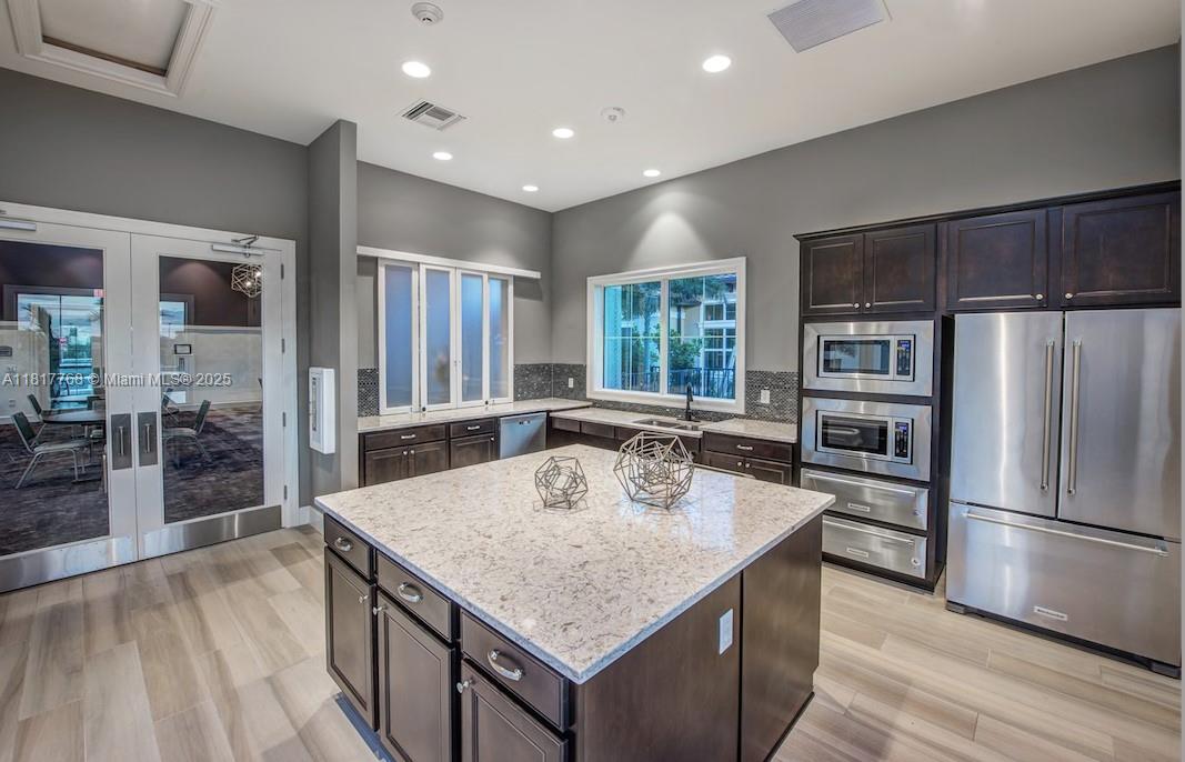 1040 Eucalyptus Drive, Unit 6 Hollywood, FL 33021 - Photo 38 of 41 a kitchen with kitchen island counter space a refrigerator and a sink