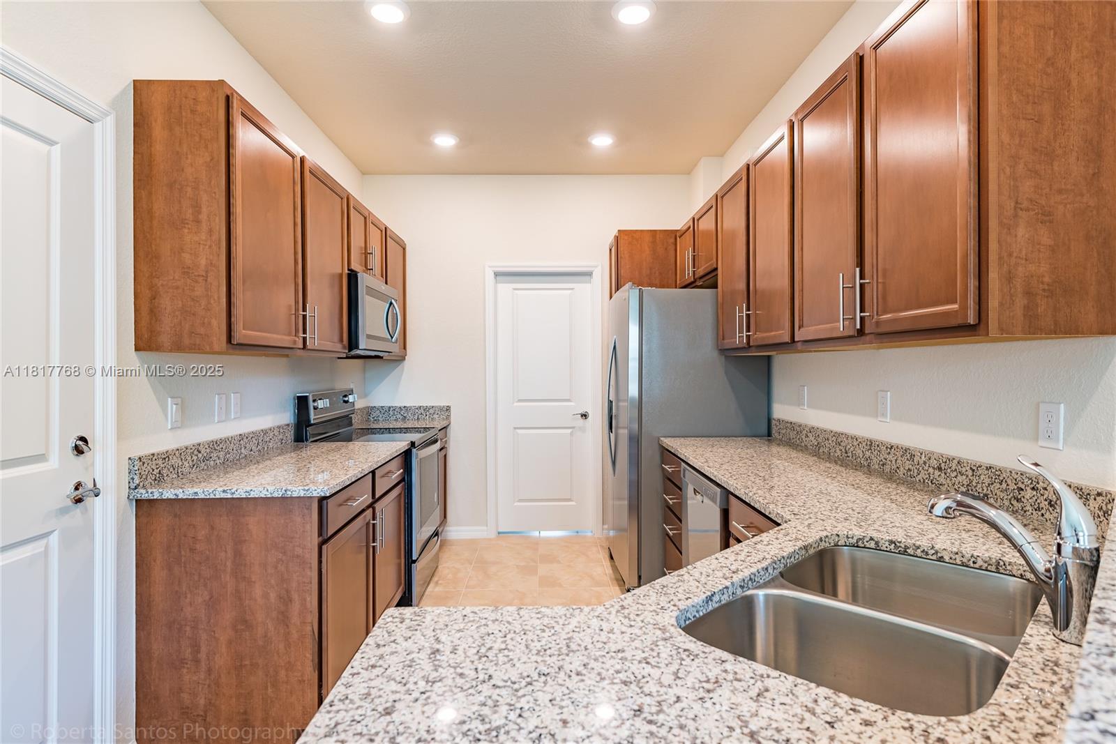1040 Eucalyptus Drive, Unit 6 Hollywood, FL 33021 - Photo 5 of 41 a kitchen with stainless steel appliances granite countertop a sink a stove and a refrigerator