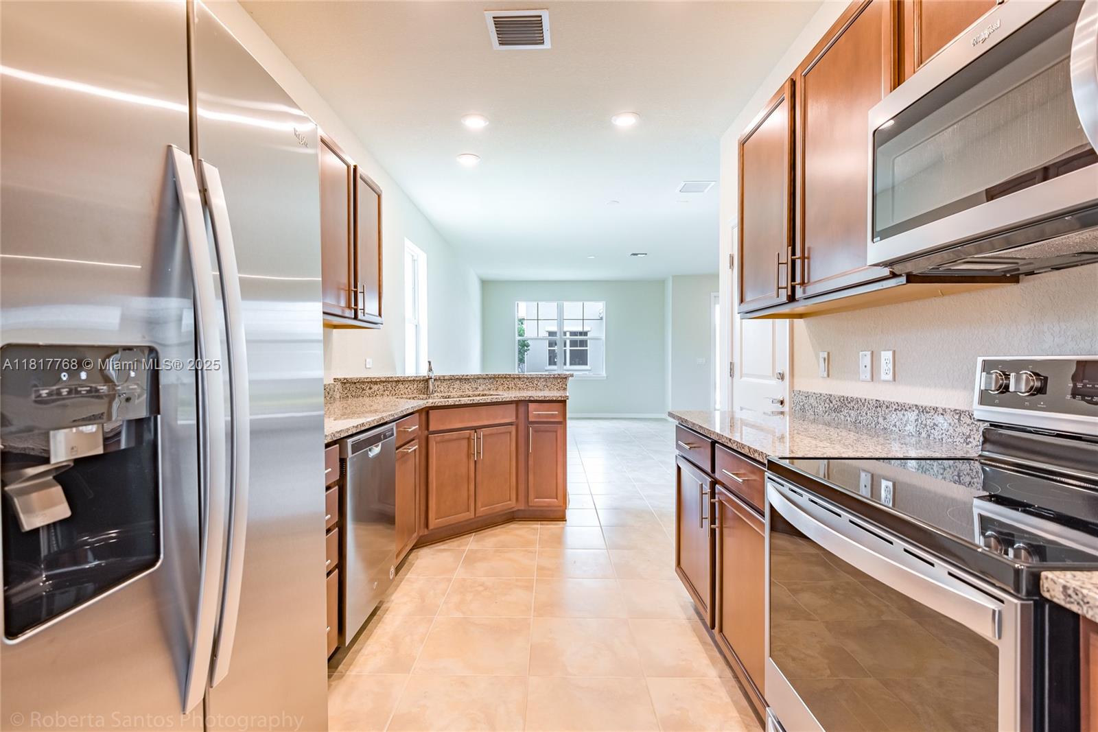1040 Eucalyptus Drive, Unit 6 Hollywood, FL 33021 - Photo 6 of 41 a kitchen with stainless steel appliances granite countertop a refrigerator a stove and a sink with wooden floor