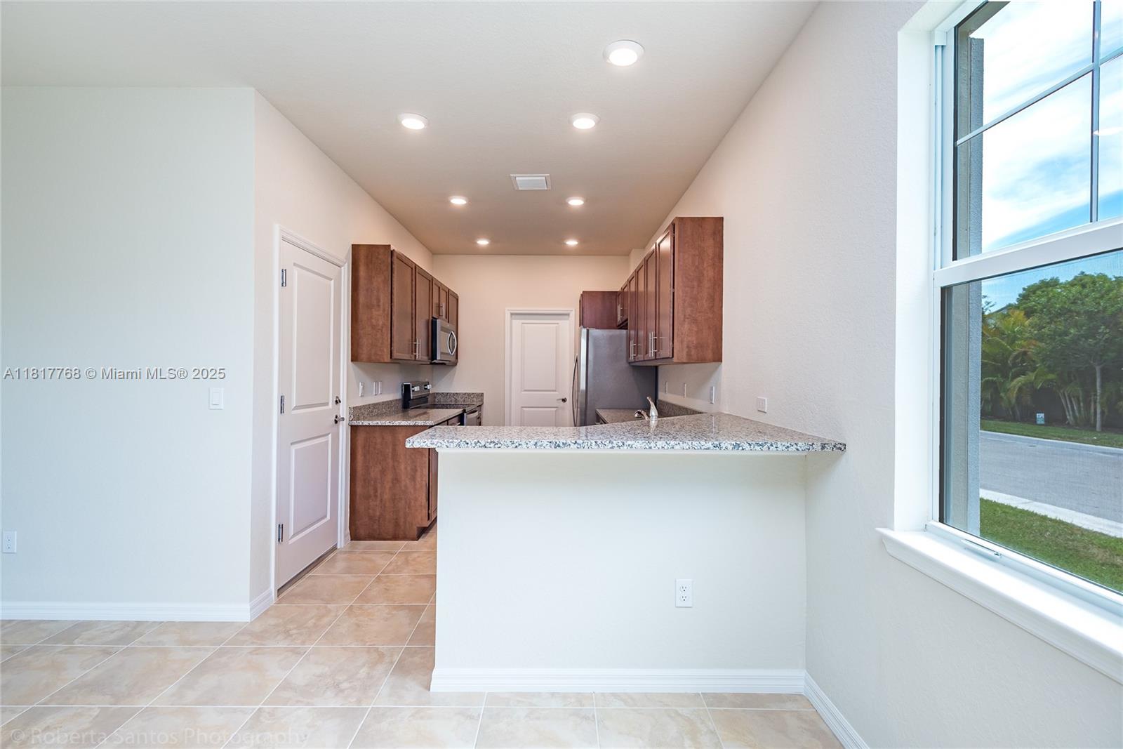 1040 Eucalyptus Drive, Unit 6 Hollywood, FL 33021 - Photo 10 of 41 a kitchen with stainless steel appliances granite countertop a sink and a refrigerator