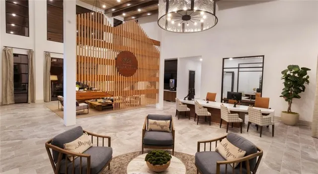 a living room with furniture a chandelier and a large window