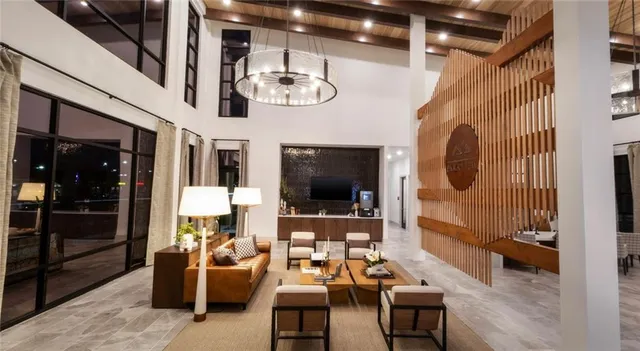 a living room with furniture a flat screen tv and kitchen view