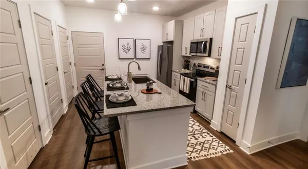 a kitchen with stainless steel appliances granite countertop a refrigerator and a stove top oven