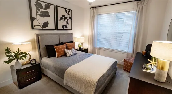 a bedroom with a bed and painting on the wall