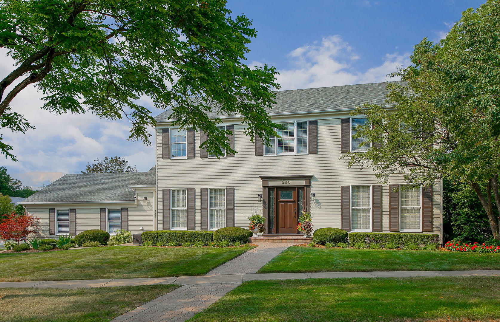 front view of a brick house with a yard
