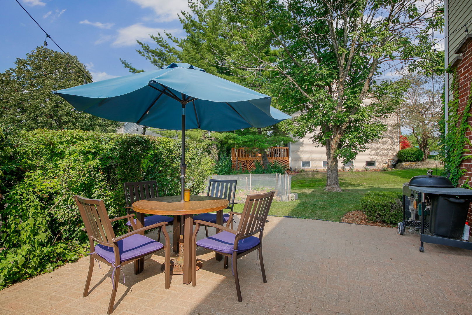 230 Hill Road Willowbrook, IL 60527 - Photo 35 of 39 a patio with a table and chairs under an umbrella